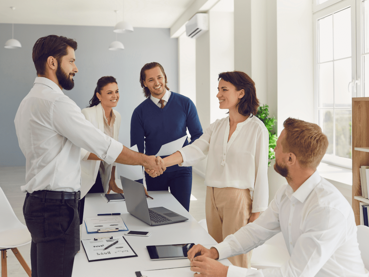 Team members shaking hands during business meeting.
